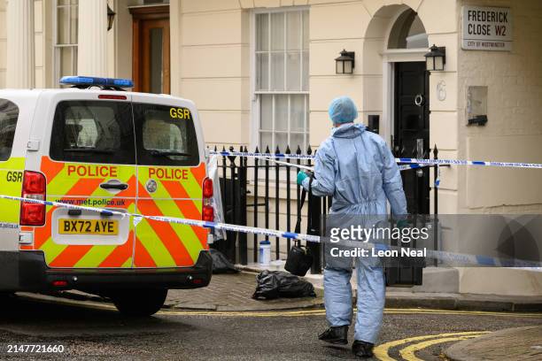 Member of the forensic search team is seen outside a residence following the discovery of a woman's body the previous day, on April 09, 2024 in...