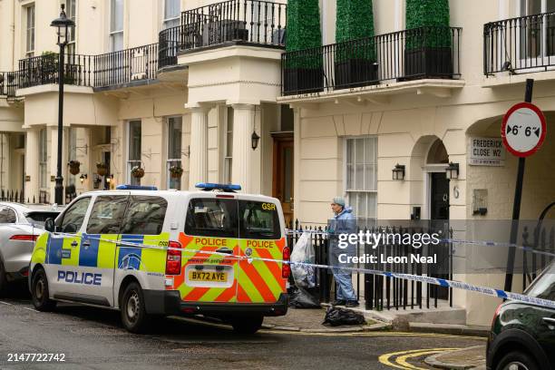 Member of the forensic search team is seen outside a residence following the discovery of a woman's body the previous day, on April 09, 2024 in...