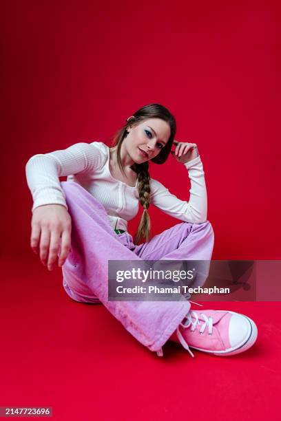 cool attitude woman on plain background - sitting on ground stock pictures, royalty-free photos & images