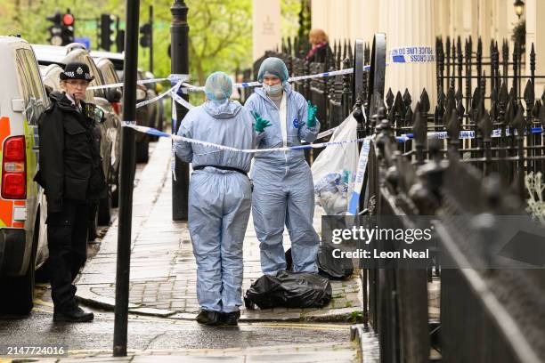 Members of the forensic search team are seen outside a residence following the discovery of a woman's body the previous day, on April 09, 2024 in...