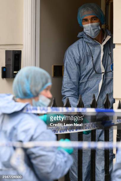 Members of the forensic search team are seen outside a residence following the discovery of a woman's body the previous day, on April 09, 2024 in...
