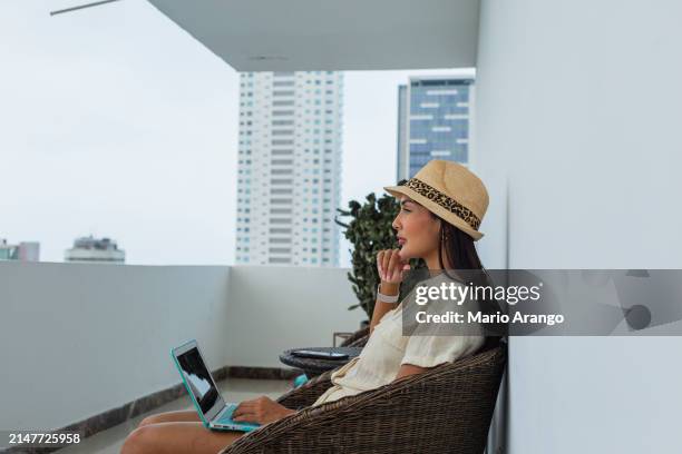 woman in the facilities of a beautiful hotel in cartagena enjoying the sun while taking care of some matters - matters stock pictures, royalty-free photos & images