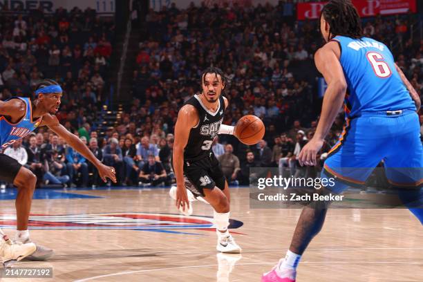 Tre Jones of the San Antonio Spurs dribbles the ball during the game against the Oklahoma City Thunder on April 10, 2024 at Paycom Arena in Oklahoma...