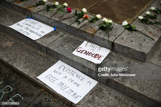 Flowers and signs lay on the ground in front of the U.S. Agency for International Development building at a vigil for aid workers killed in the Gaza...