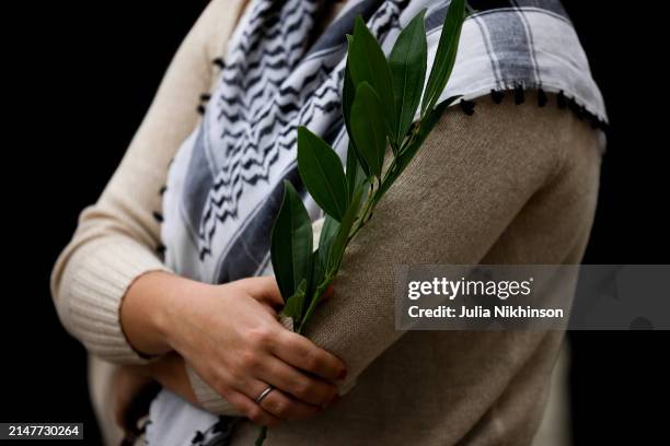 Woman holds a plant during a vigil for aid workers killed in the Gaza war on April 11, 2024 in Washington, DC. Seven World Central Kitchen aid...