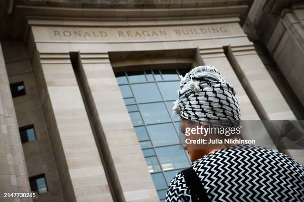 Woman wears a Palestinian keffiyeh in front of the U.S. Agency for International Development during a vigil for aid workers killed in the Gaza war on...