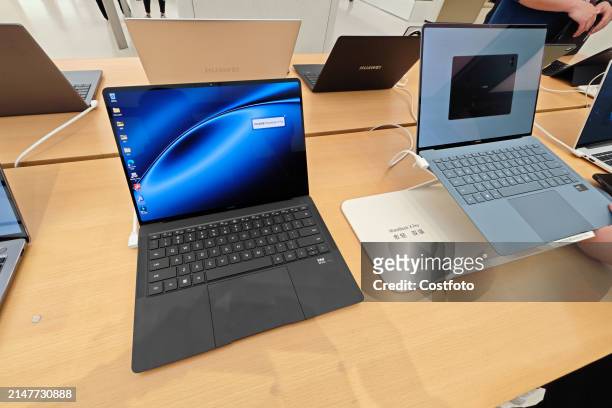 Customers experience the MateBook X Pro, a newly released laptop from Huawei, at the Huawei flagship store on Nanjing Road in Shanghai, China, April...