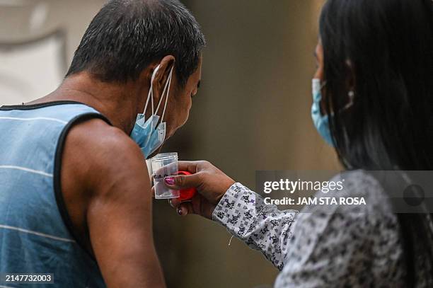 In this photo taken on March 14 a man spits a sputum sample during a tuberculosis screening at a health centre in Valenzuela. A faster and vastly...
