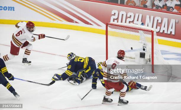 Will Smith of the Boston College Eagles scores against Jake Barczewski of the Michigan Wolverines in the first period during the NCAA Men's Hockey...