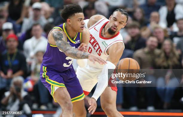 Keyonte George of the Utah Jazz passes off under pressure from Aaron Holiday of Houston Rockets during the first half of their game at the Delta...