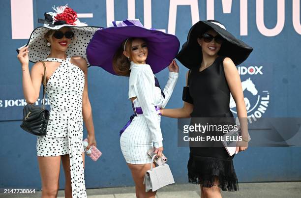 Racegoers pose for a photograph as they attend on Ladies Day, the second day of the Grand National Festival horse race meeting at Aintree Racecourse...