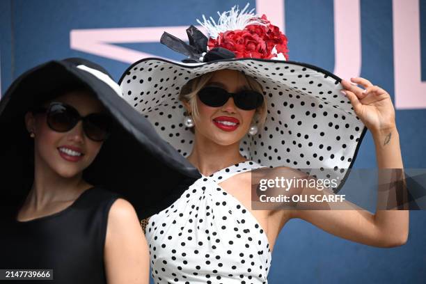 Racegoers pose for a photograph as they attend on Ladies Day, the second day of the Grand National Festival horse race meeting at Aintree Racecourse...