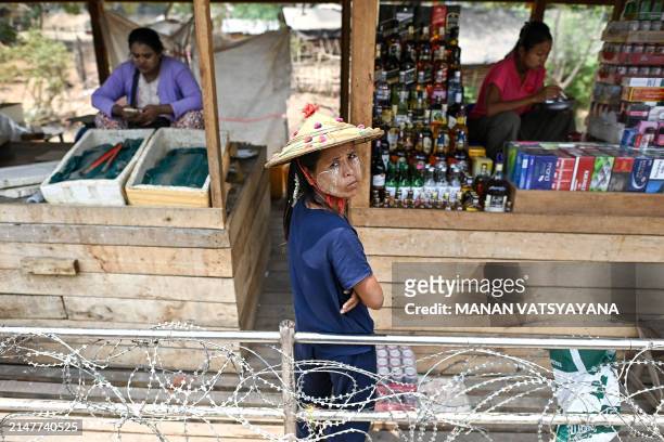 Myanmar vendor selling alcohol, cigarettes and aphrodisiac looks on while waiting for customers inside a "no-man's land" between Thailand and...