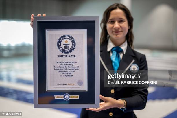 Guinness World Records official adjudicator Anouk de Timary poses holding the certificate of the world's largest number mosaic ever made from...