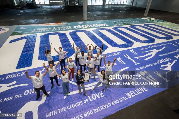 Team pose with Guinness World Records official adjudicator Anouk de Timary showing the certificate after breaking the record of the World's largest...