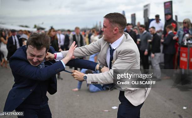 Racegoers fight each other as they scuffle on the second day of the Grand National Festival horse race meeting at Aintree Racecourse in Liverpool,...