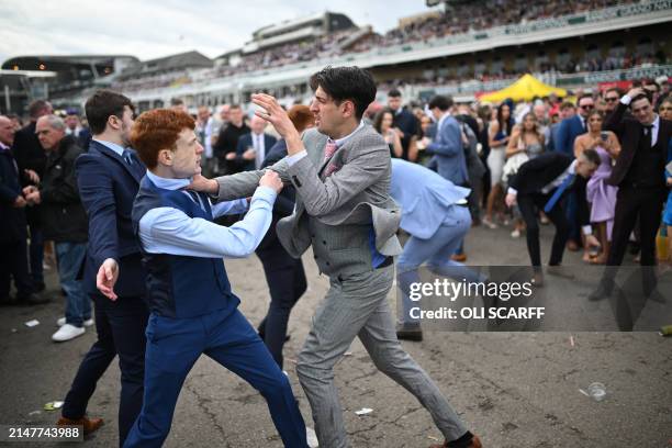 Racegoers fight each other as they scuffle on the second day of the Grand National Festival horse race meeting at Aintree Racecourse in Liverpool,...
