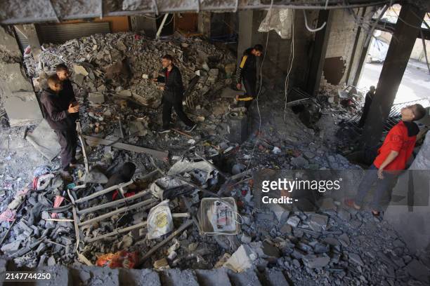 Palestinians inspect the damage to the home of the Tabatibi family after Israeli bombardment in the Daraj Neighbourhood of Gaza on April 12 during...