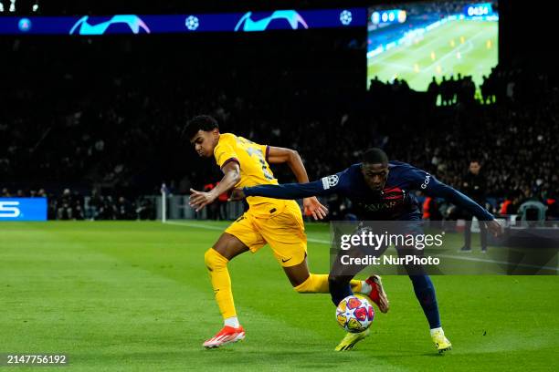Lamine Yamal right winger of Barcelona and Spain and Nuno Mendes left-back of PSG and Portugal compete for the ball during the UEFA Champions League...
