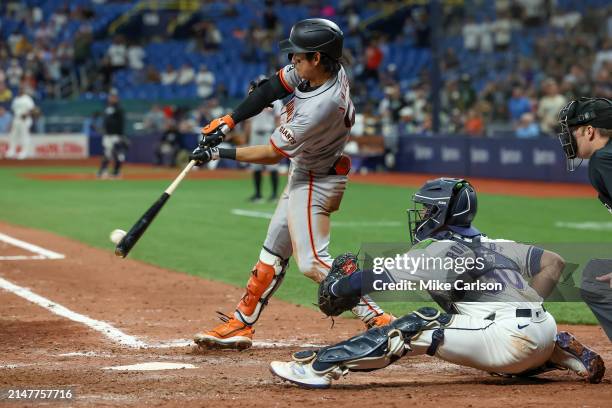 Jung Hoo Lee of the San Francisco Giants lines out in front of Ben Rortvedt of the Tampa Bay Rays during the ninth inning of a baseball game at...