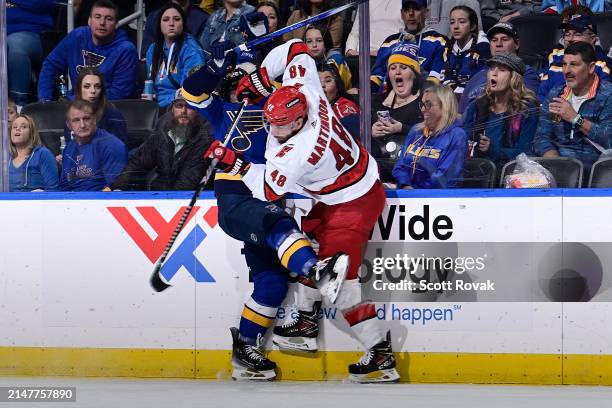 Nathan Walker of the St. Louis Blues and Jordan Martinook of the Carolina Hurricanes collide on April 12, 2024 at the Enterprise Center in St. Louis,...