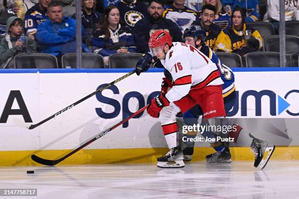 Zach Dean of the St. Louis Blues and Brady Skjei of the Carolina Hurricanes battle for the puck on April 12, 2024 at the Enterprise Center in St....