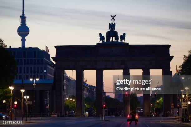 April 2024, Berlin: Early morning view of the Brandenburg Gate and the television tower. Photo: Joerg Carstensen/dpa