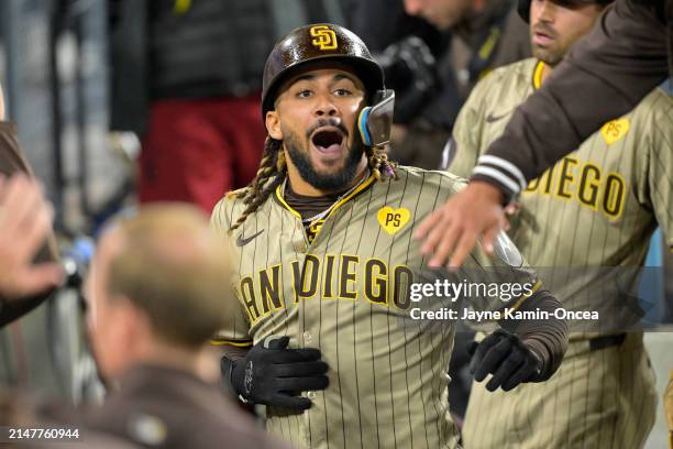 Fernando Tatis Jr. #23 of the San Diego Padres is congratulated in the dugout after hitting a two run home run in the seventh inning against the Los...