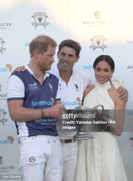 The Duchess of Sussex presents the trophy to her husband, the Duke of Sussex after his team the Royal Salute Sentebale Team defeated the Grand...
