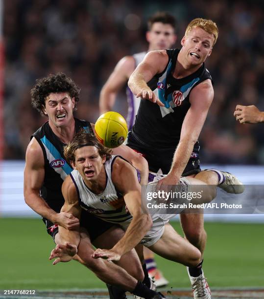 Darcy Byrne-Jones of the Power and Nat Fyfe of the Dockers and Willem Drew of the Power during the 2024 AFL Round 05 match between the Port Adelaide...