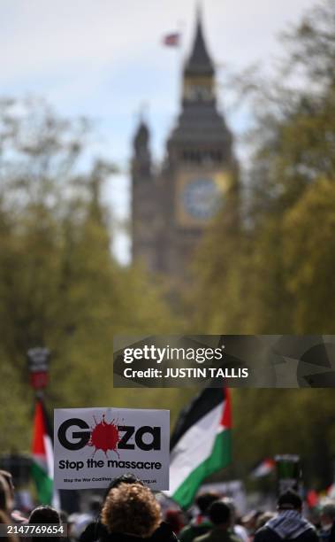 Pro-Palestinian activists and supporters wave flags and hold placards as during a protest march near the the Houses of Parliament in central London,...