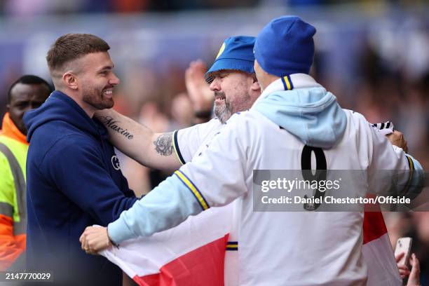 Stuart Dallas of Leeds United stops to thank fans as he walks a lap of the stadium with his family at half time after announcing his retirement from...