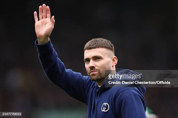 Stuart Dallas of Leeds United waves to fans as he walks a lap of the stadium with his family at half time after announcing his retirement from...
