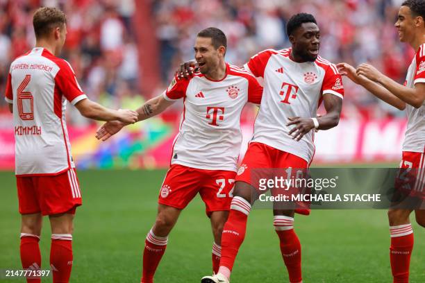 Bayern Munich's Portuguese defender Raphael Guerreiro celebrates scoring the opening goal with his teammates during the German first division...