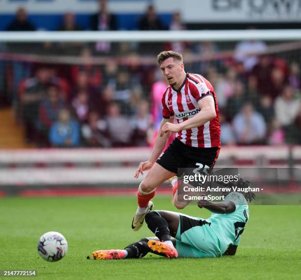 Lincoln City's Alex Mitchell vies for possession with Wigan Athletic's Baba Adeeko during the Sky Bet League One match between Lincoln City and Wigan...