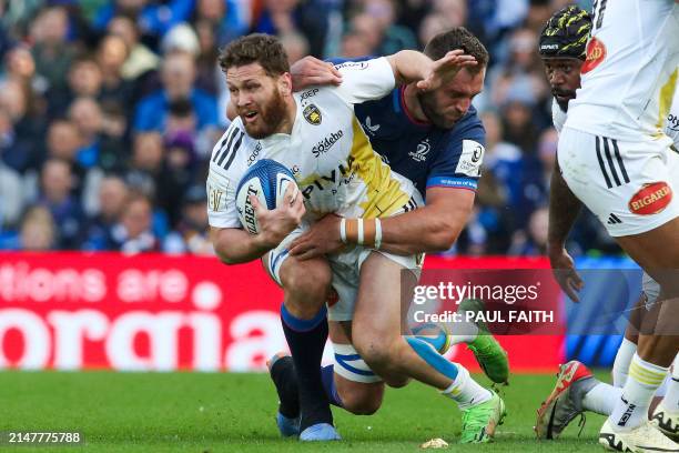 La Rochelle's New Zealand scrum-half Tawera Kerr-Barlow is tackled by Leinster's South African lock Jason Jenkins during the European Rugby Champions...
