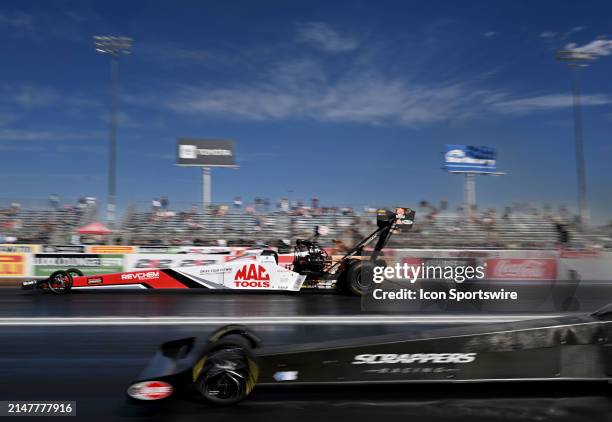 Top Fuel driver Doug Kalitta, far lane, heads down track against Jasmine Salinas, near lane, during the second round of qualifying at the NHRA 4-Wide...