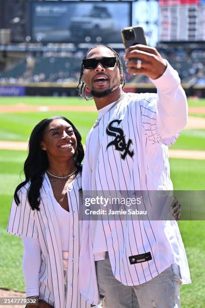 Gymnast Simone Biles and Jonathan Owens of the Chicago Bears record a video on the field before Owens threw out a first pitch before a game between...