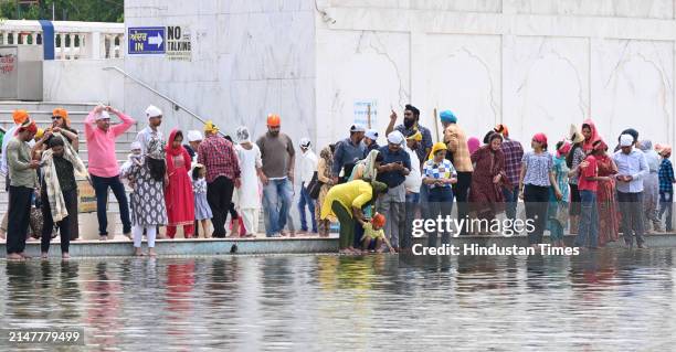 Devotees take a dip in the sacred pond of Gurudwara Bangla Sahib on the occasion of Baisakhi festival, on April 13, 2024 in New Delhi, India....