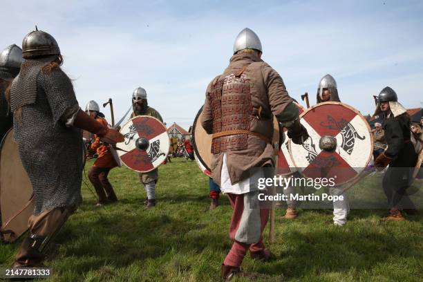 Warriors with axes drawn prepare to attack their enemy in a battle re-enactment at the Viking festival on April 13, 2024 in Sheringham, United...