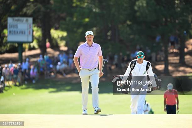 Cam Davis of Australia with his caddie Andrew Tschudin walk to the ninth green during the third round of Masters Tournament at Augusta National Golf...