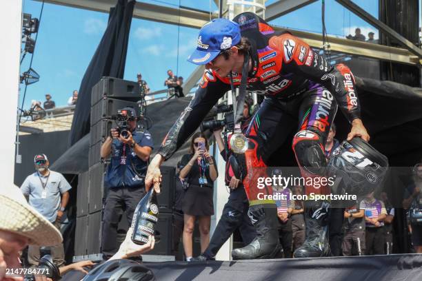 Maverick Viñales of Spain and Aprilia Racing Team hands is prosecco bottle to a fan after the Tissot Sprint Race at the MotoGP Red Bull Grand Prix of...