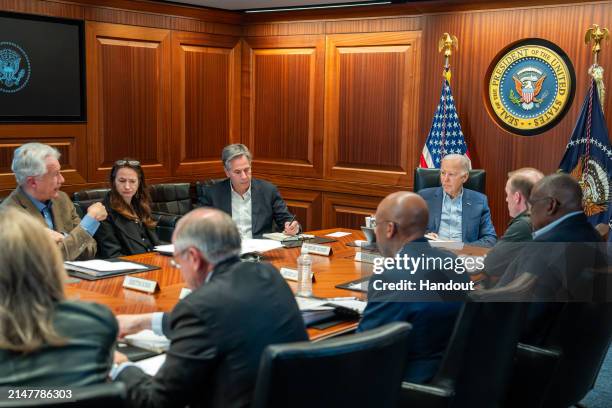 In this handout photo provided by the White House, US President Joe Biden meets with members of the National Security team regarding the unfolding...