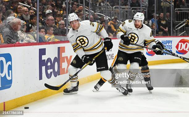 Brandon Carlo of the Boston Bruins goes for a loose puck in the first period during the game against the Pittsburgh Penguins at PPG PAINTS Arena on...