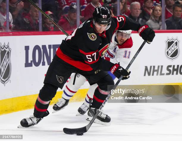 Shane Pinto of the Ottawa Senators controls the puck against Brendan Gallagher of the Montreal Canadiens during the second period at Canadian Tire...