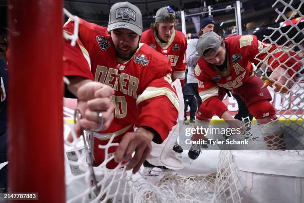 Paxton Geisel of the Denver Pioneers cuts off part of the net after defeating Boston College at the Division I Men's Ice Hockey Championship held at...