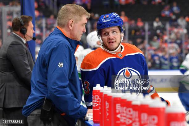 Mattias Janmark of the Edmonton Oilers has a discussion with head equipment manager Jeff Lang during warm ups before the game against Vancouver...