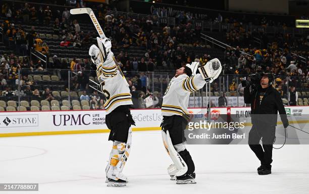 Linus Ullmark of the Boston Bruins celebrates with Jeremy Swayman following a 6-4 win over the Pittsburgh Penguins during the game at PPG PAINTS...