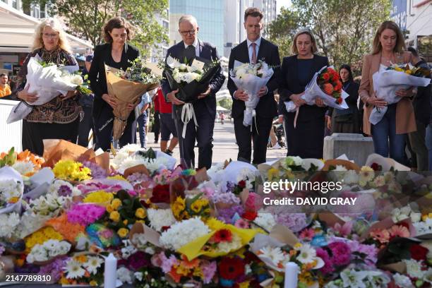 Australian Prime Minister Anthony Albanese stands with New South Wales Premier Chris Minns and other officials as they prepare to leave flowers...