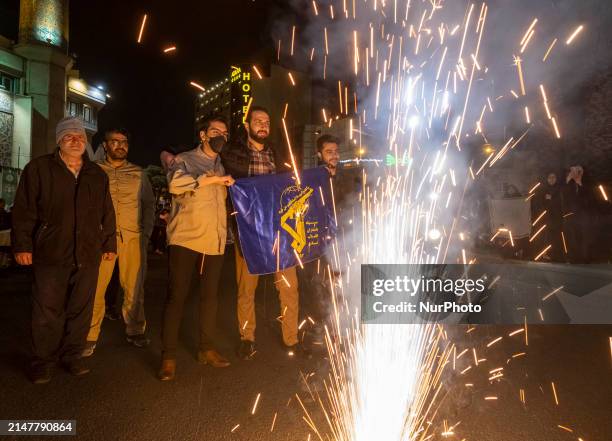 Iranians are celebrating Iran's IRGC UAV and missile attack against Israel, with one person holding a flag of the Islamic Revolutionary Guard Corps ,...